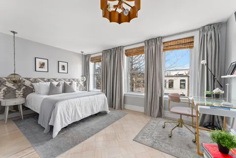 a spacious bedroom with a bed and a large window