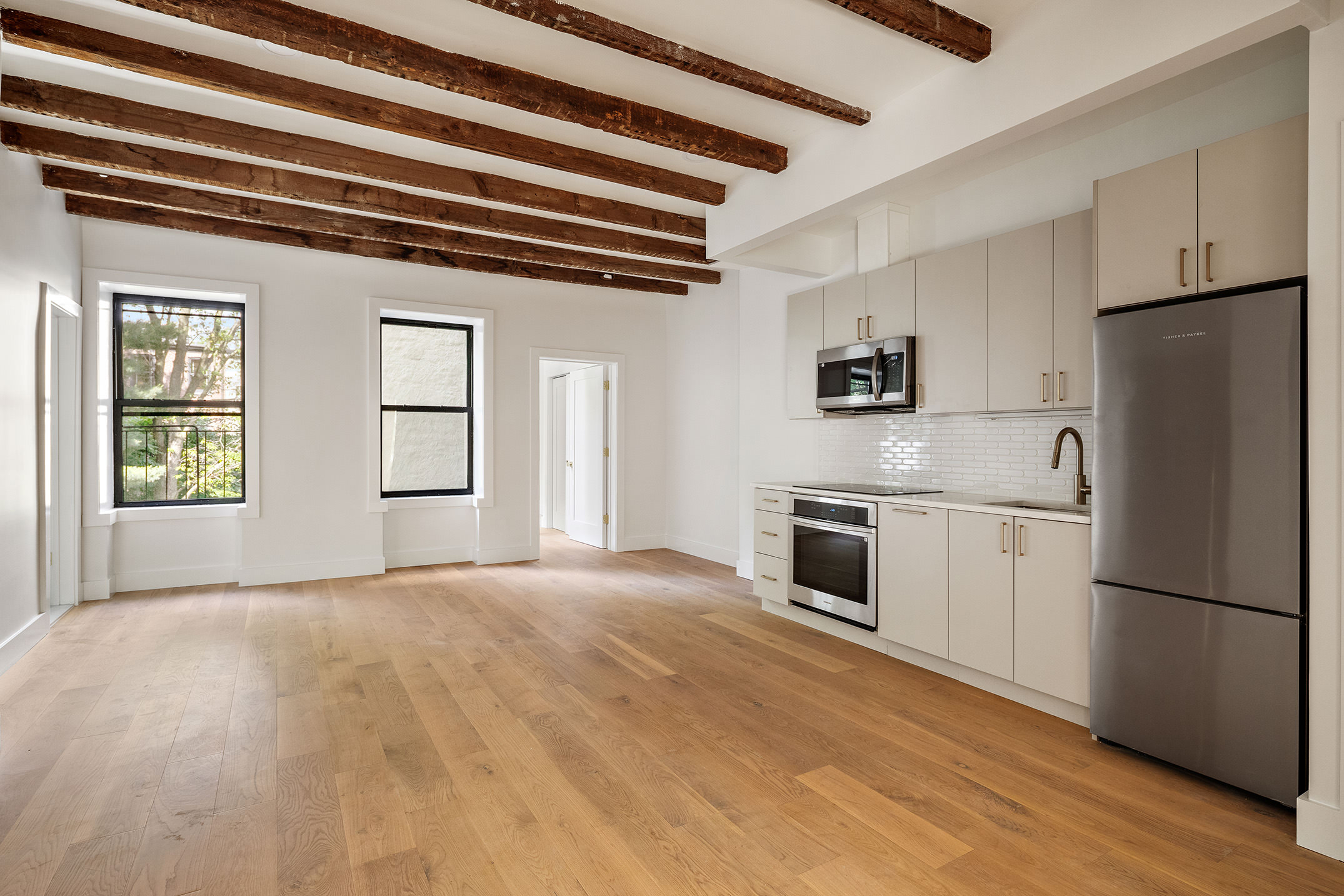 324 Clermont Avenue, Unit 4 Brooklyn, NY 11205 - Photo 3 of 9 a kitchen with stainless steel appliances granite countertop a refrigerator a stove a sink and a dishwasher next to a window