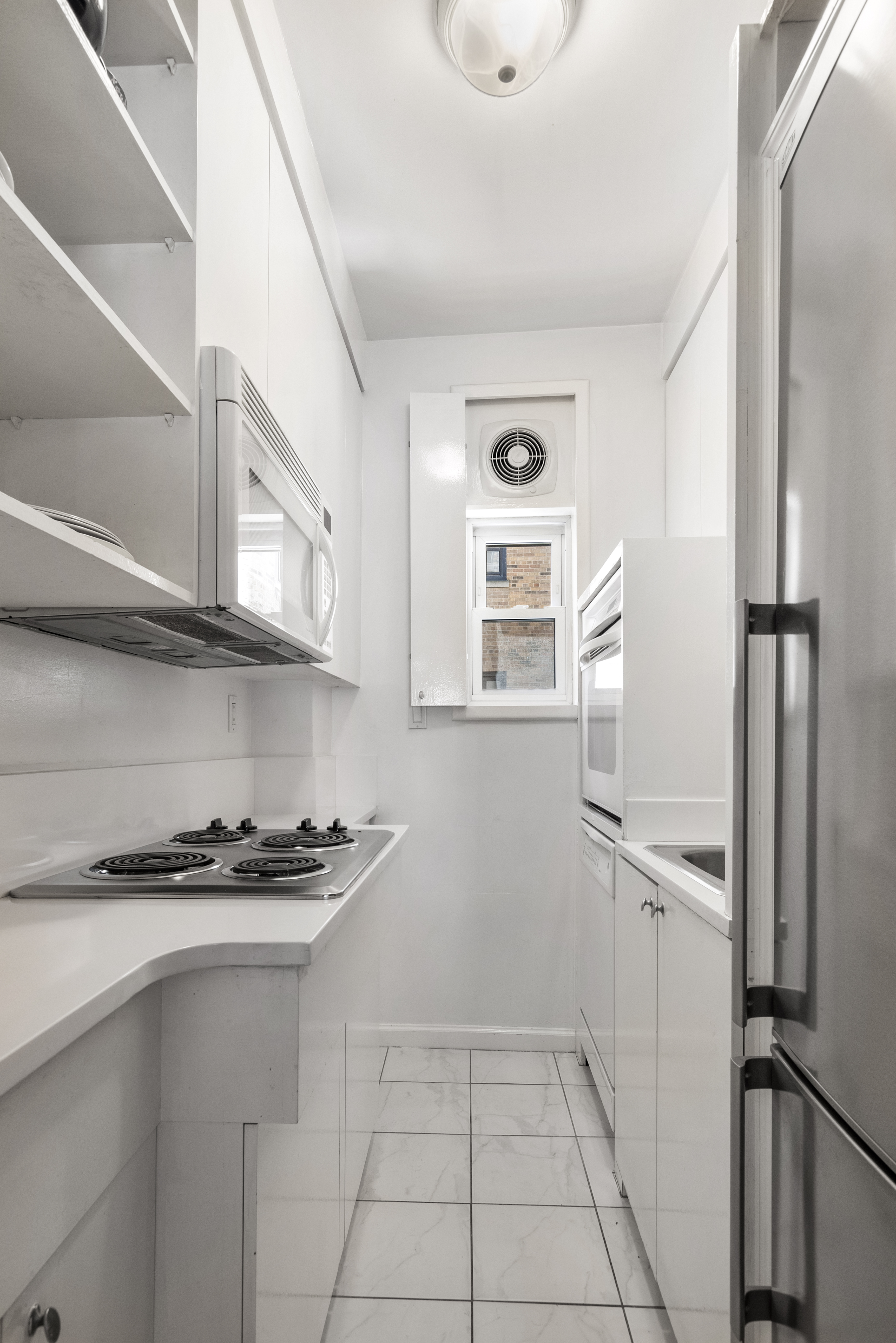 575 Park Avenue, Unit 407 Manhattan, NY 10065 - Photo 8 of 14 a kitchen with stainless steel appliances a refrigerator and a stove top oven