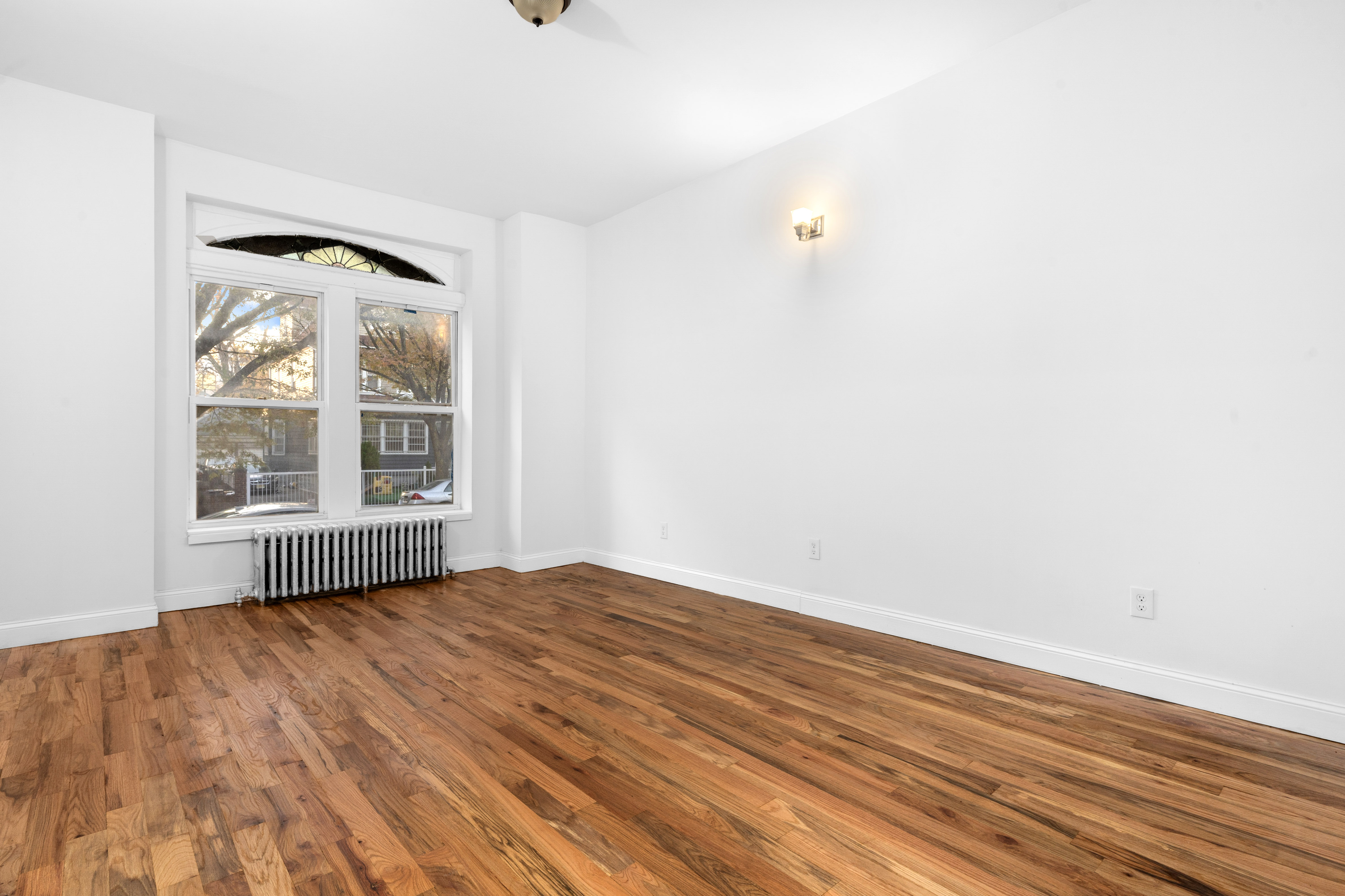 339 East 29th Street Brooklyn, NY 11226 - Photo 15 of 21 an empty room with wooden floor and windows