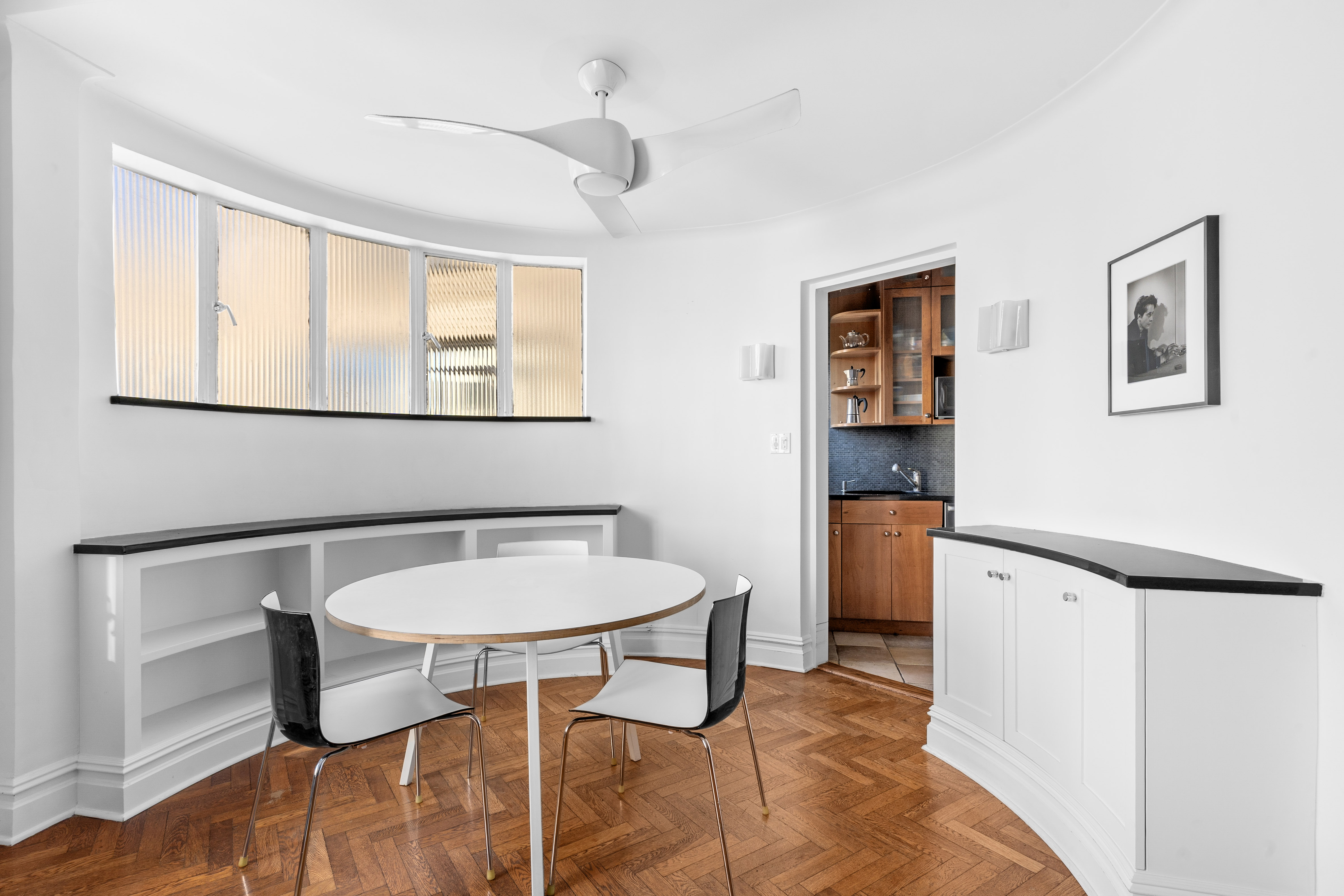 140 Riverside Drive, Unit 12E Manhattan, NY 10024 - Photo 3 of 6 a kitchen with a table chairs refrigerator and sink