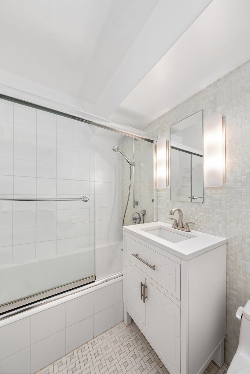 415 East 52nd Street, Unit 9AA Manhattan, NY 10022 - Photo 6 of 10 a bathroom with a sink a toilet and shower