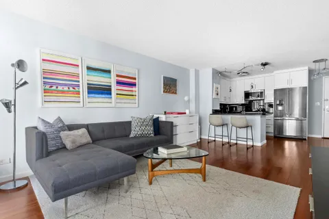 a living room with furniture and a view of kitchen