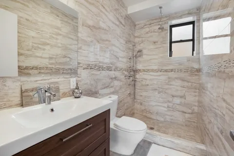 a bathroom with a sink a toilet and shower