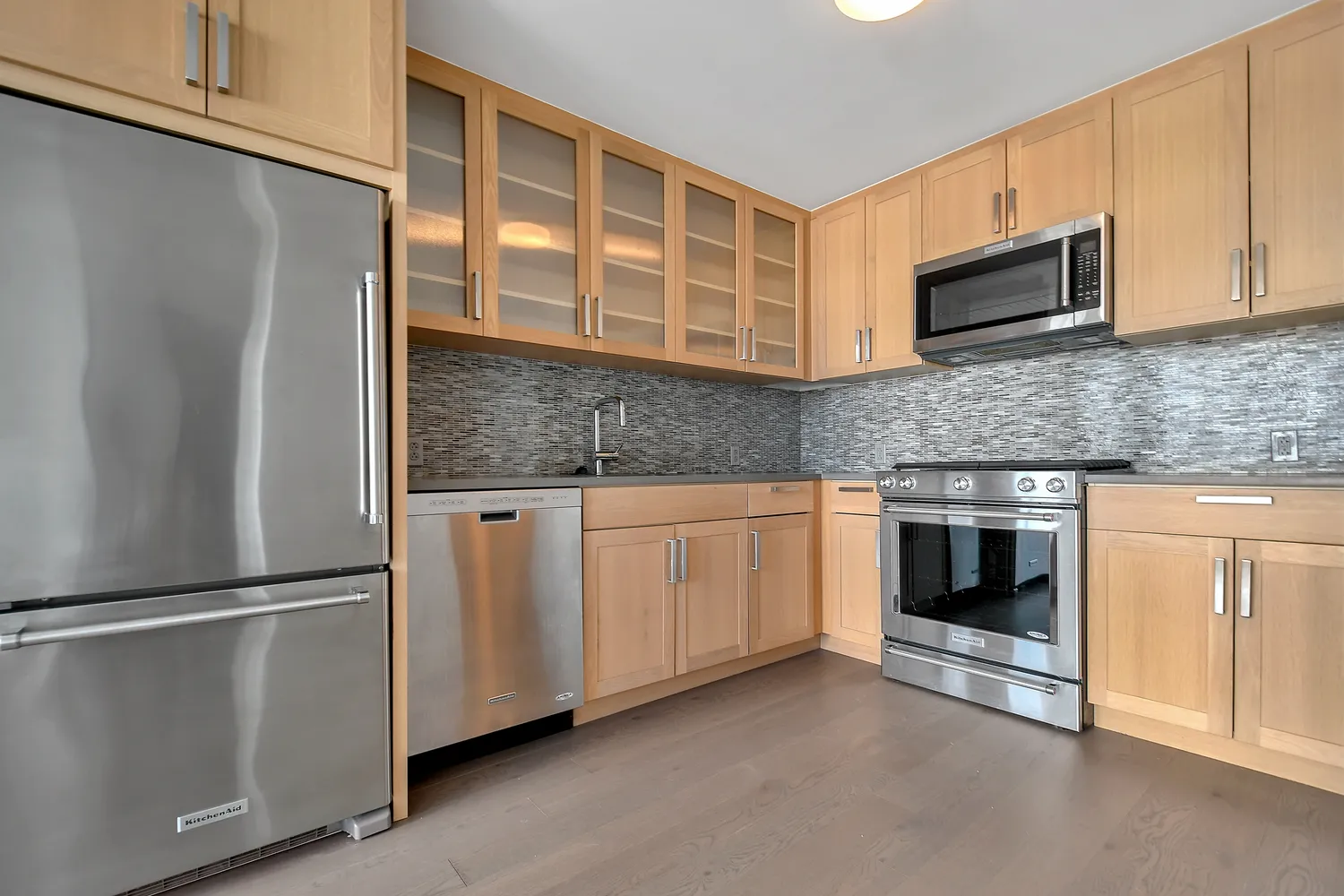 a kitchen with granite countertop white cabinets stainless steel appliances and a counter space