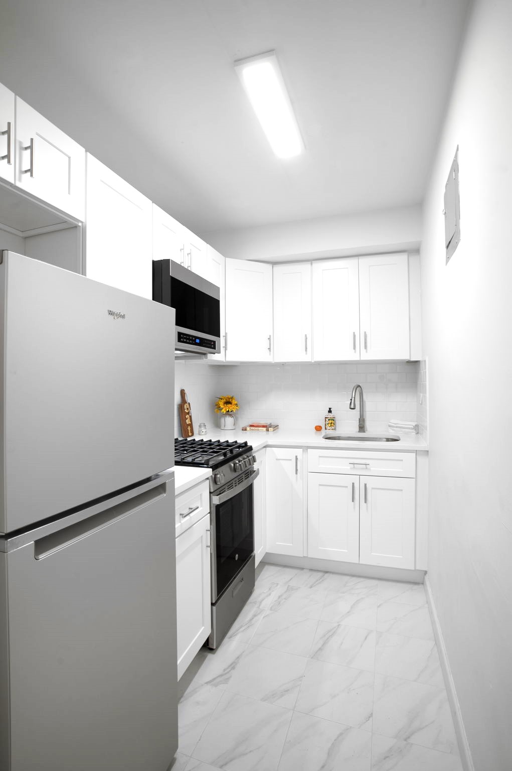 150 East 61st Street, Unit 8B Manhattan, NY 10065 - Photo 19 of 30 a kitchen with a refrigerator stove and sink