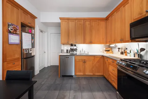 a kitchen with stainless steel appliances granite countertop a refrigerator stove top oven and sink