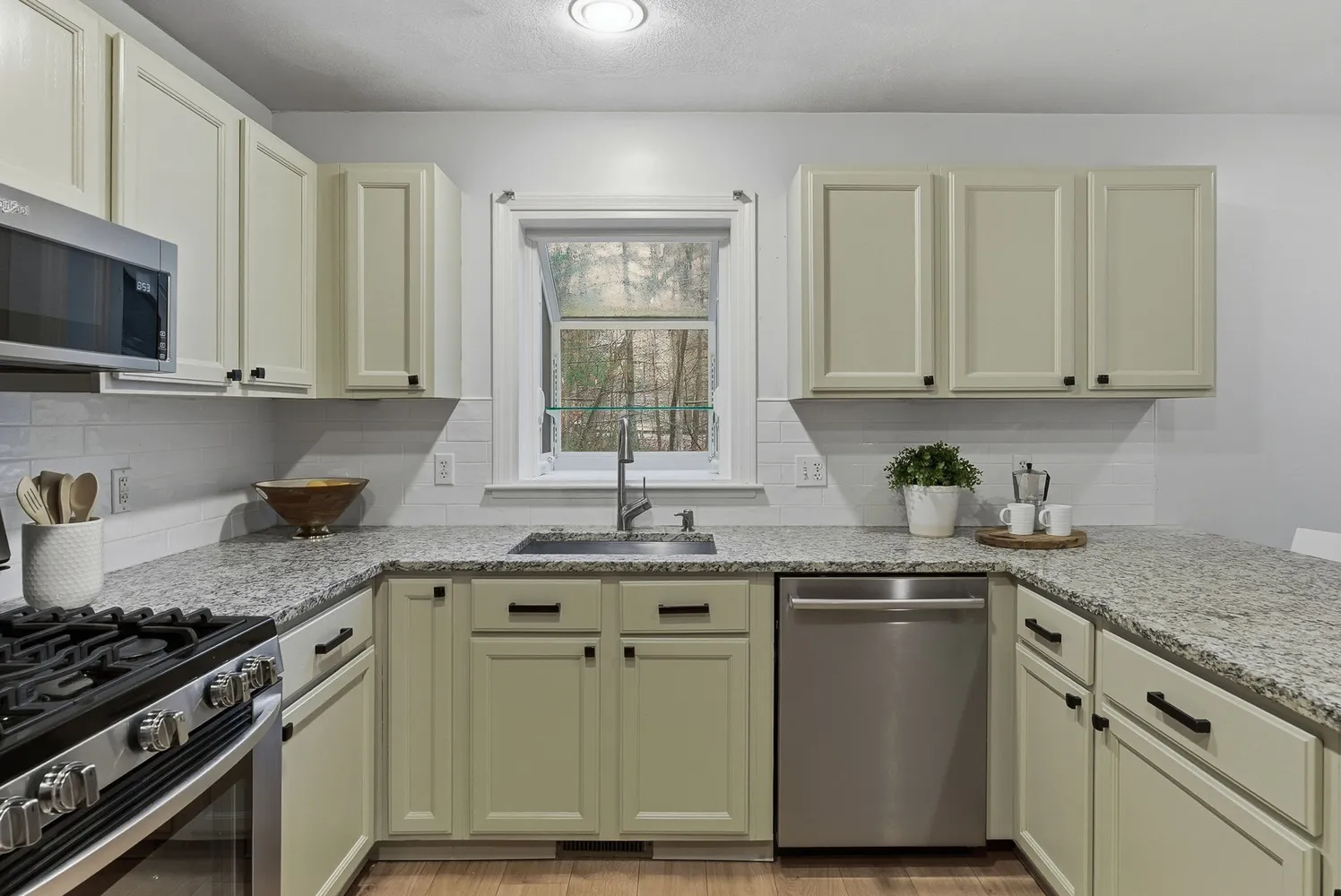 a kitchen with stainless steel appliances granite countertop a sink stove and cabinets