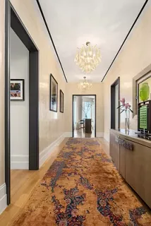 a view of a hallway with wooden floor and livingroom