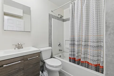 a bathroom with a sink a toilet and shower curtain