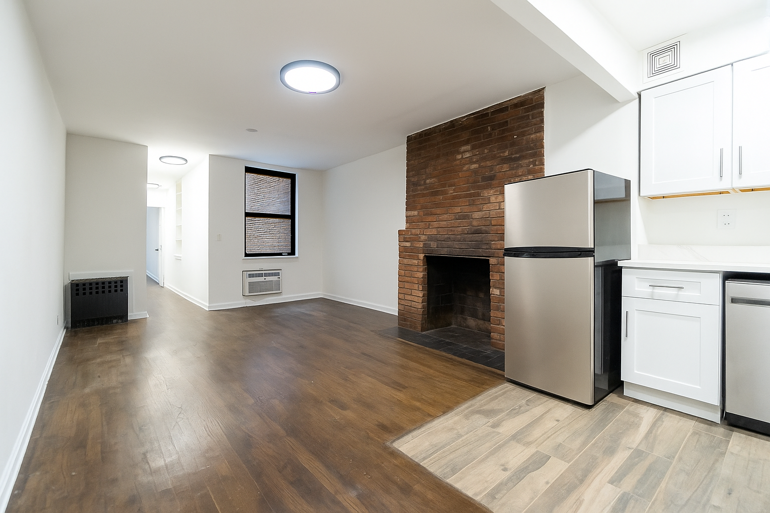 205 2nd Avenue, Unit 2C Manhattan, NY 10003 - Photo 5 of 15 an empty room with wooden floor and way to kitchen