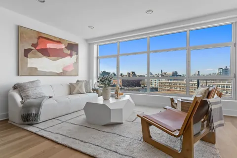 a living room with furniture city view and large windows