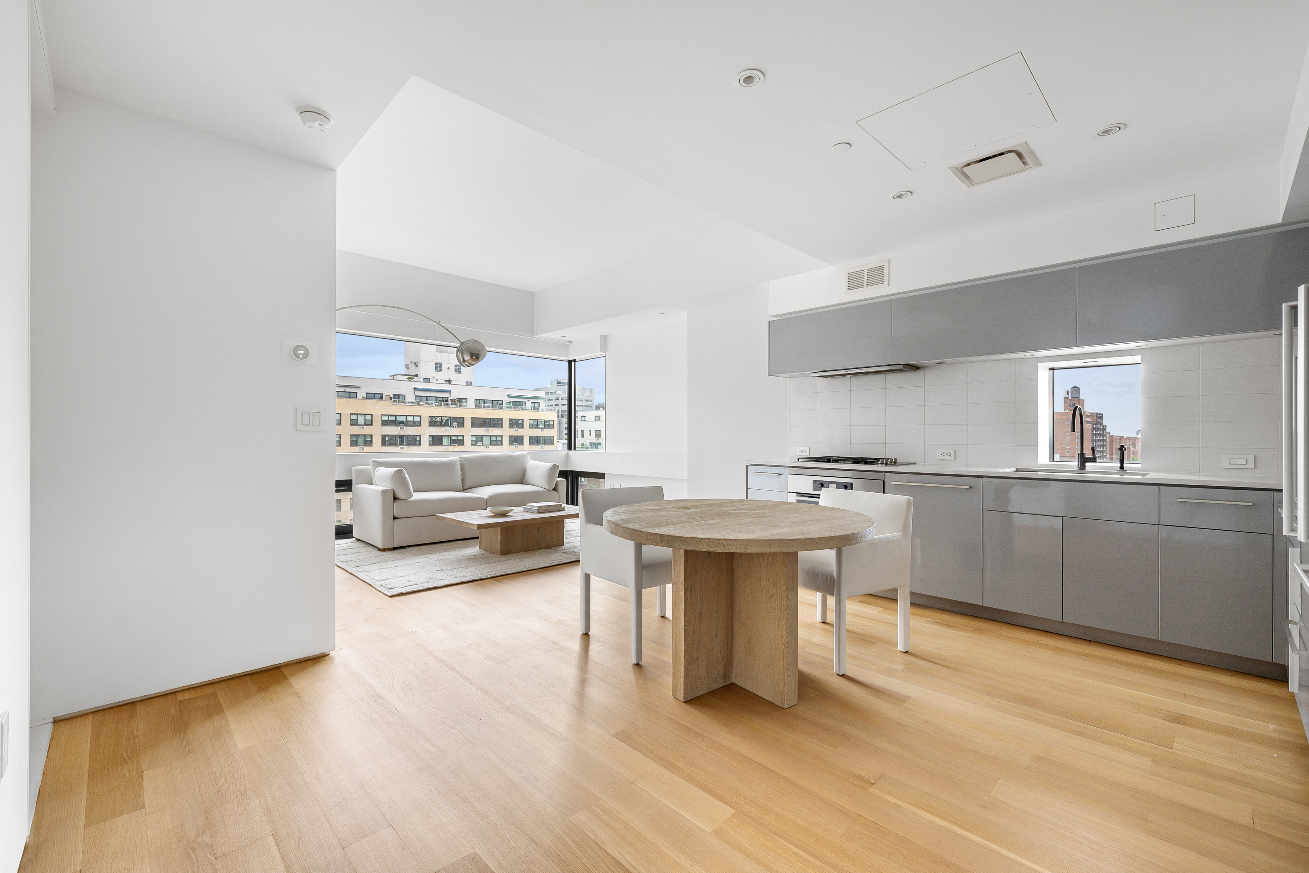 a kitchen with a sink and chairs with wooden floor
