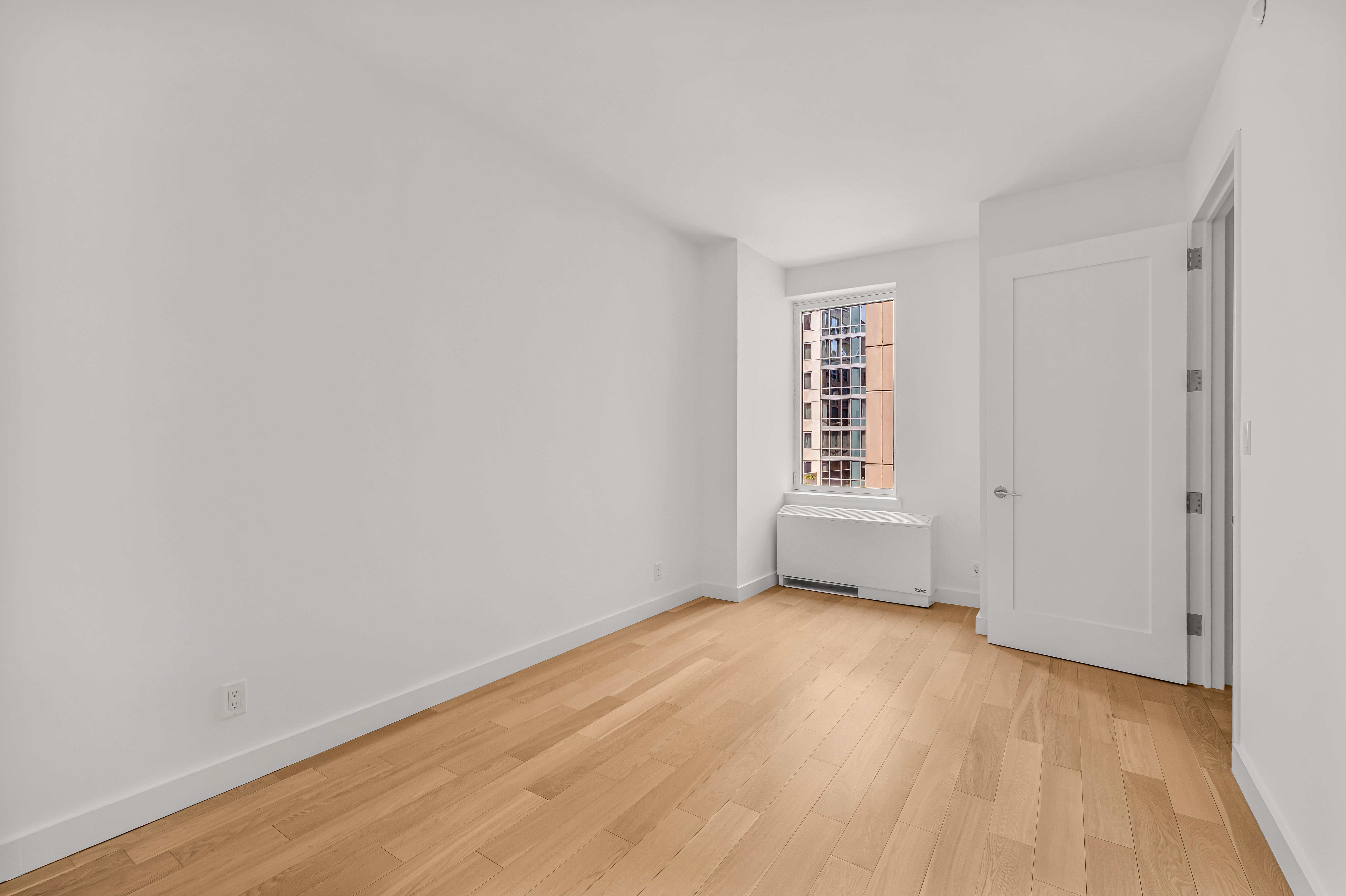 34 North 7th Street, Unit 3Z Brooklyn, NY 11249 - Photo 5 of 14 a view of an empty room with wooden floor and a window