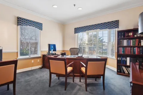 a dining room with furniture and a floor to ceiling window