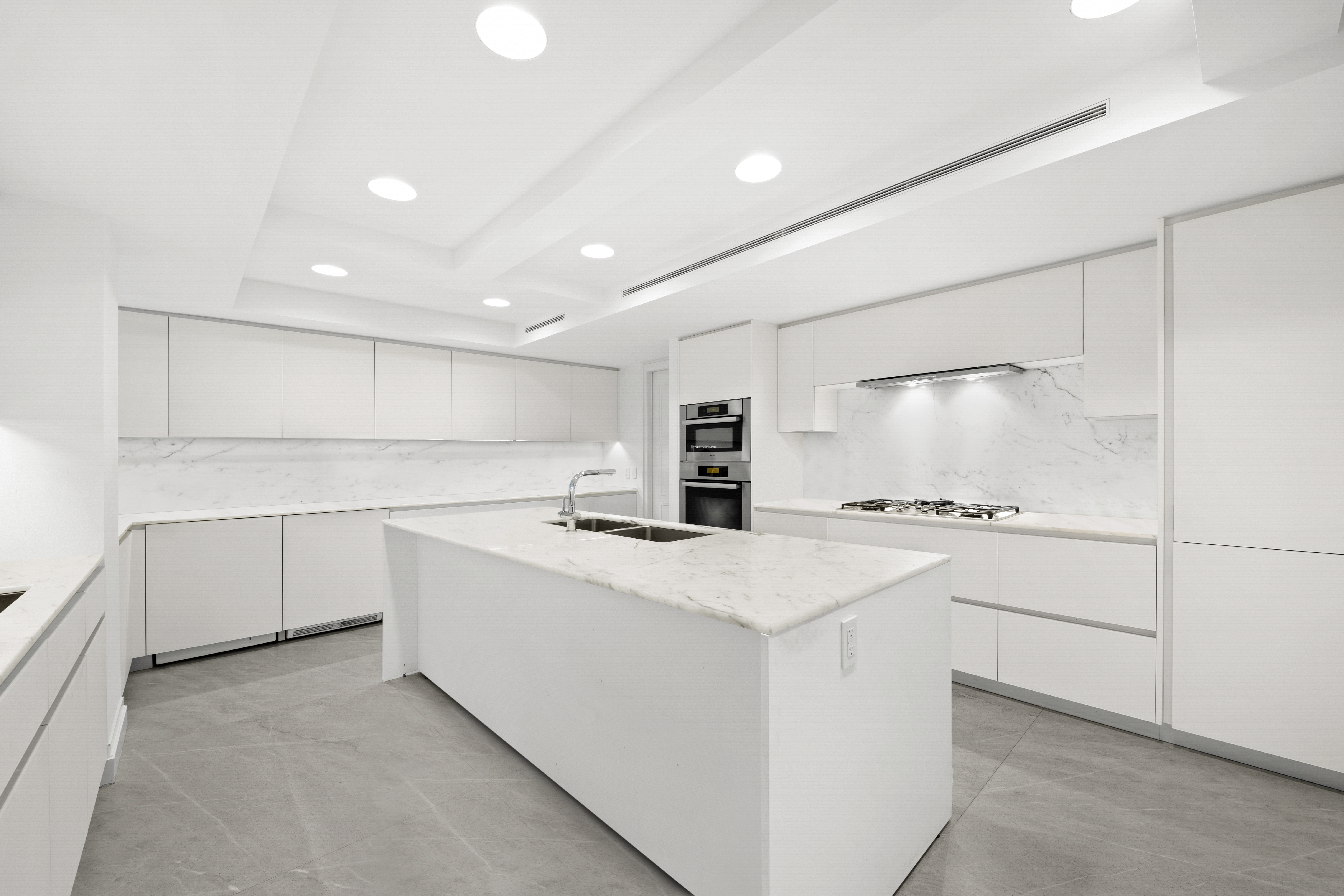 737 Park Avenue, Unit 6A Manhattan, NY 10021 - Photo 8 of 14 a kitchen with white cabinets and white appliances