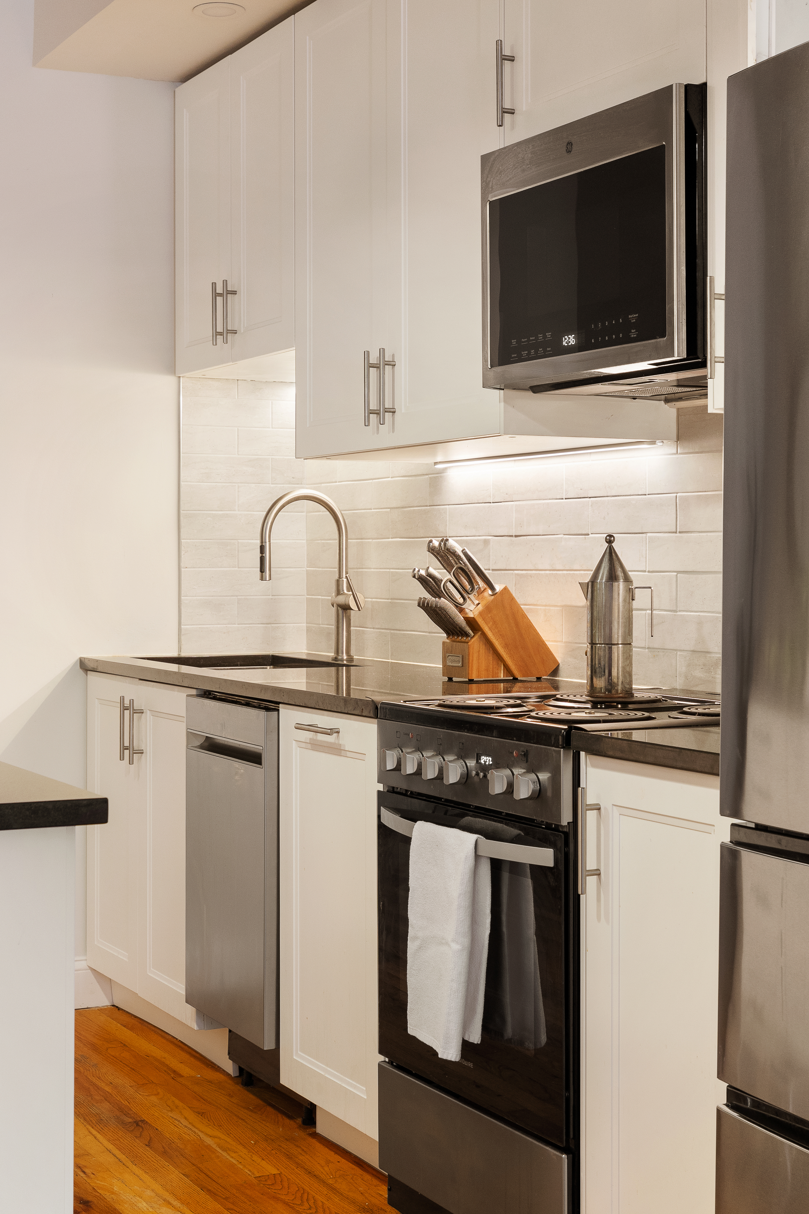 23 Waverly Place, Unit 5DE Manhattan, NY 10003 - Photo 4 of 16 a kitchen with a stove and a microwave