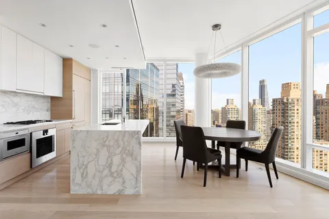 a view of a a dining room with furniture window and wooden floor