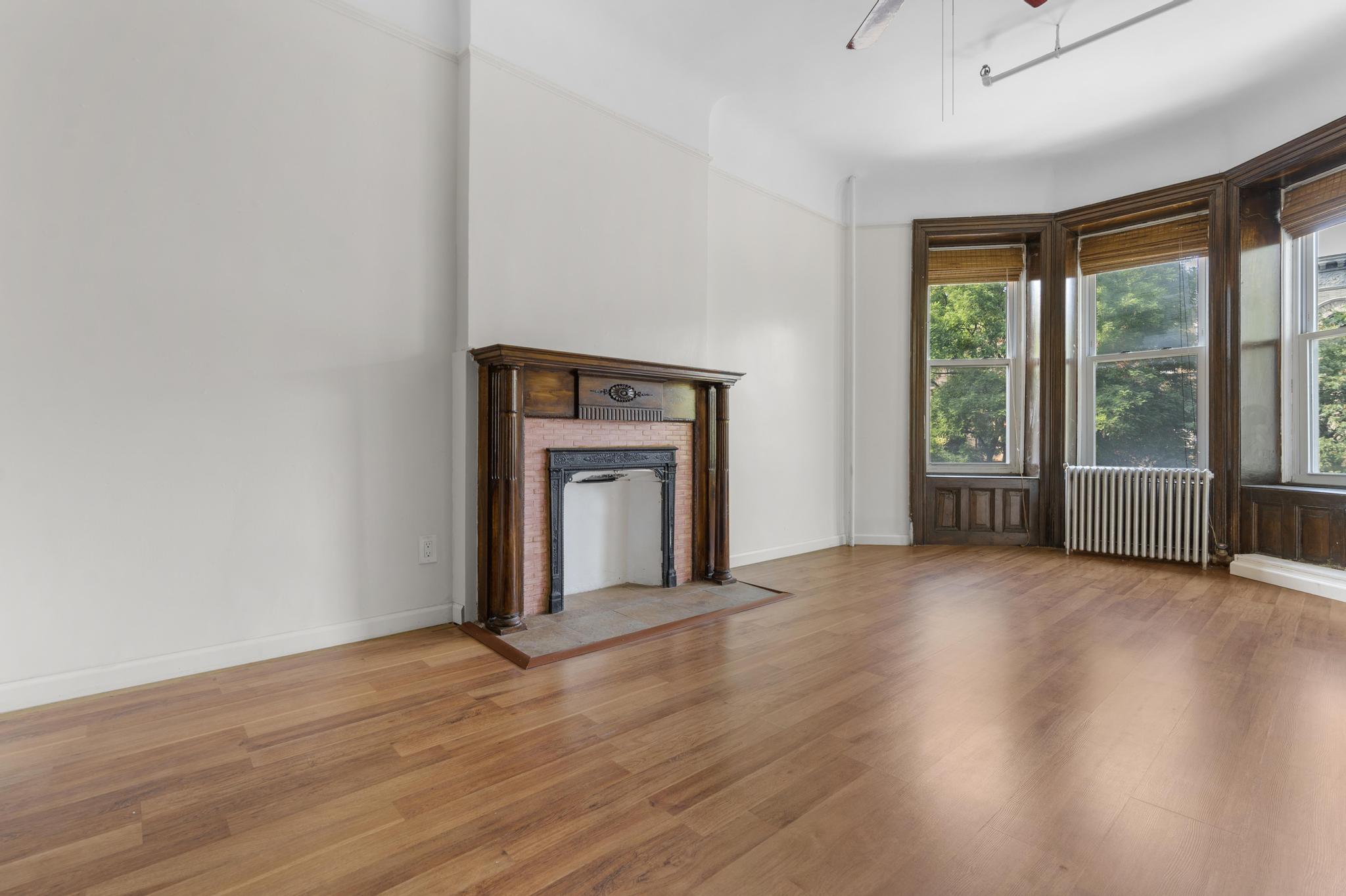 880 Park Place, Unit 2 Brooklyn, NY 11216 - Photo 3 of 12 an empty room with wooden floor and windows