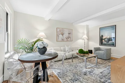 a living room with furniture and a painting on the wall
