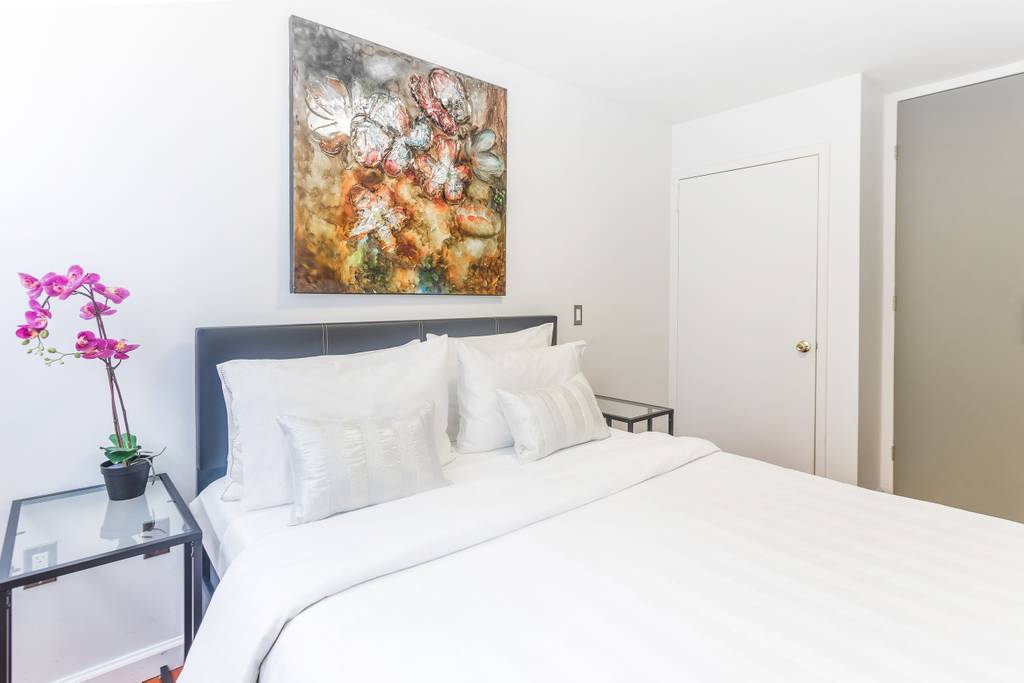 153 Stanton Street, Unit A1 Manhattan, NY 10002 - Photo 3 of 16 a bedroom with a bed and a potted plant