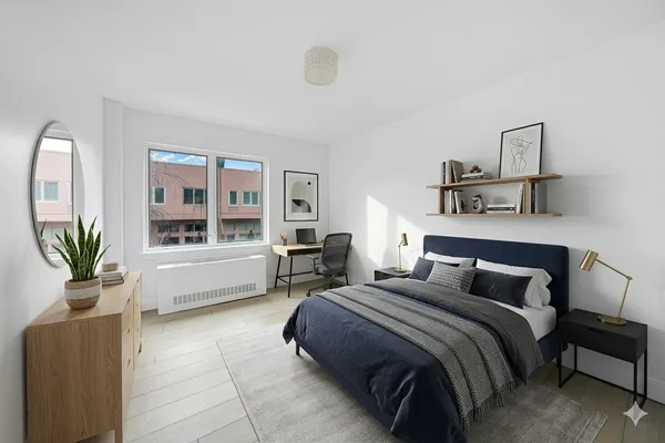 a bedroom with a large bed and a potted plant