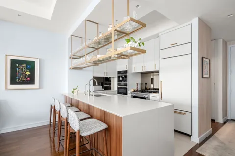 a kitchen with stainless steel appliances a table chairs and a refrigerator
