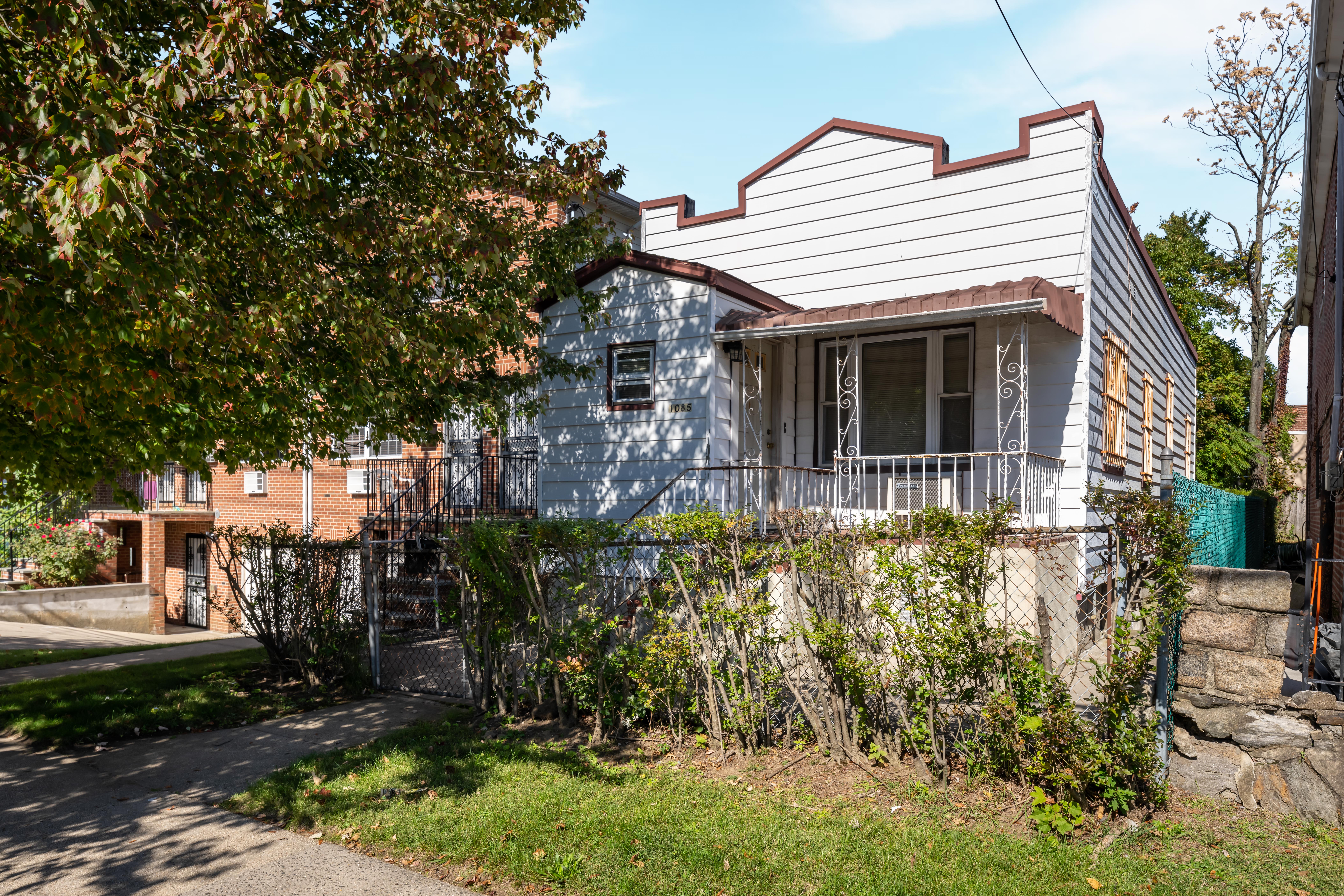 1085 Arnow Avenue Bronx, NY 10469 - Photo 1 of 16 a front view of a house with a garden