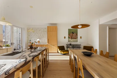 a kitchen with a table chairs stove and wooden floor