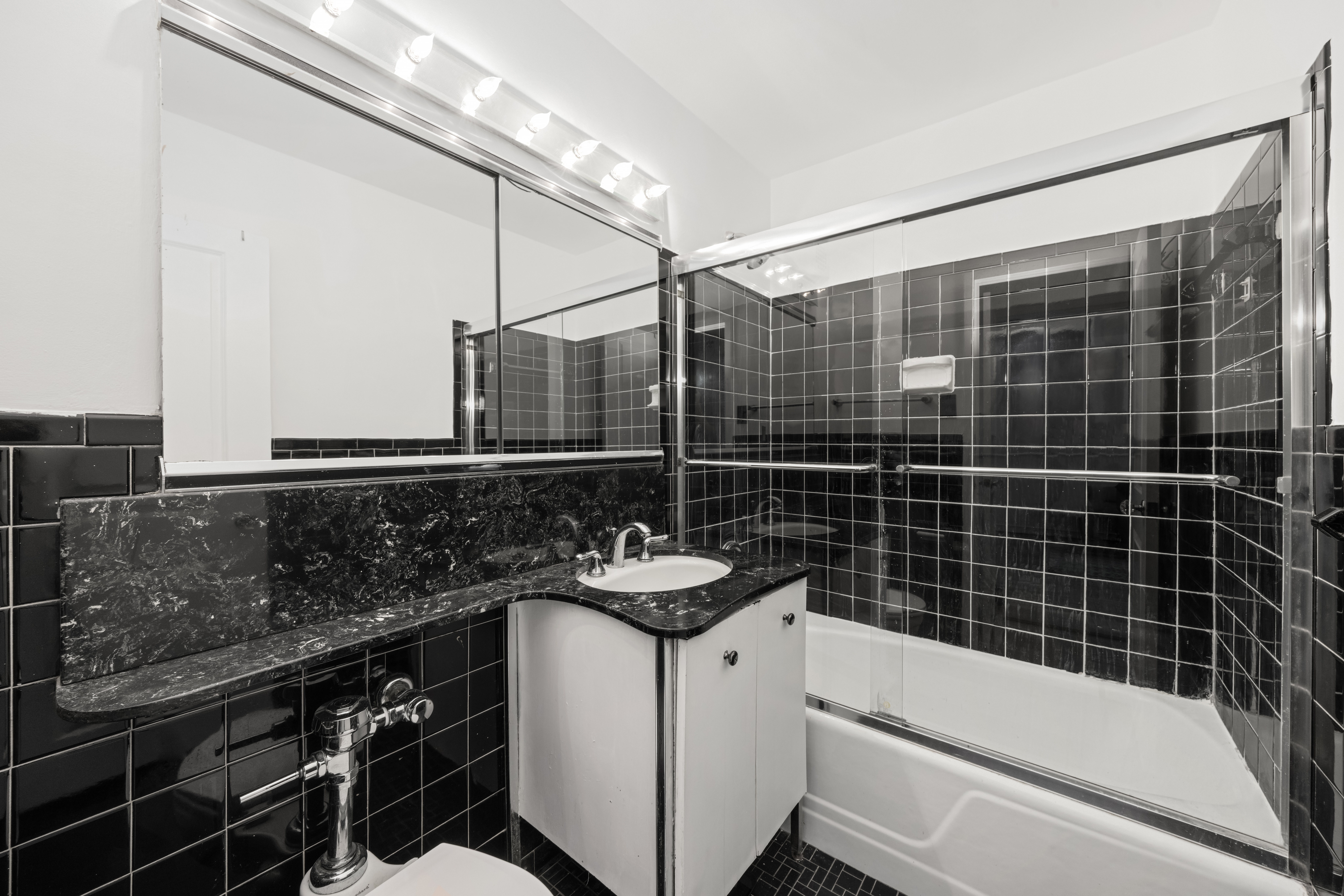 1160 3rd Avenue, Unit 2J Manhattan, NY 10065 - Photo 7 of 8 a bathroom with a granite countertop sink a toilet a mirror and shower