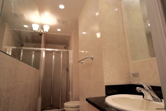 126 East 83rd Street, Unit A2 Manhattan, NY 10028 - Photo 5 of 5 a bathroom with a sink a toilet a mirror and shower