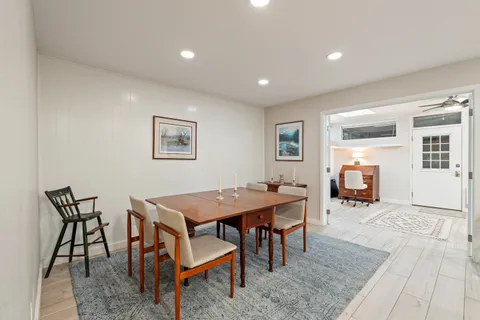 a living room with stainless steel appliances furniture and kitchen view