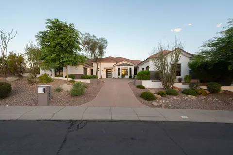 a front view of a house with a yard and potted plants