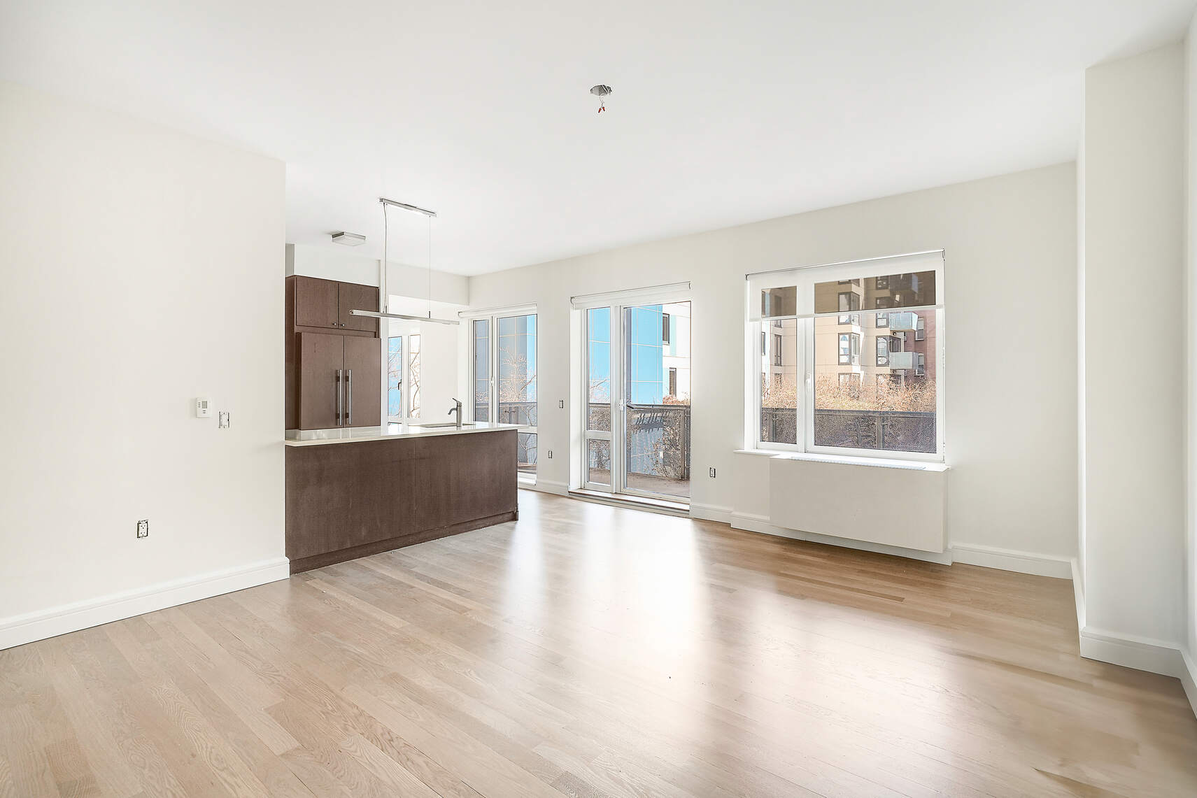 454 West 54th Street, Unit 3A Manhattan, NY 10019 - Photo 4 of 13 a view of an empty room with wooden floor and a window
