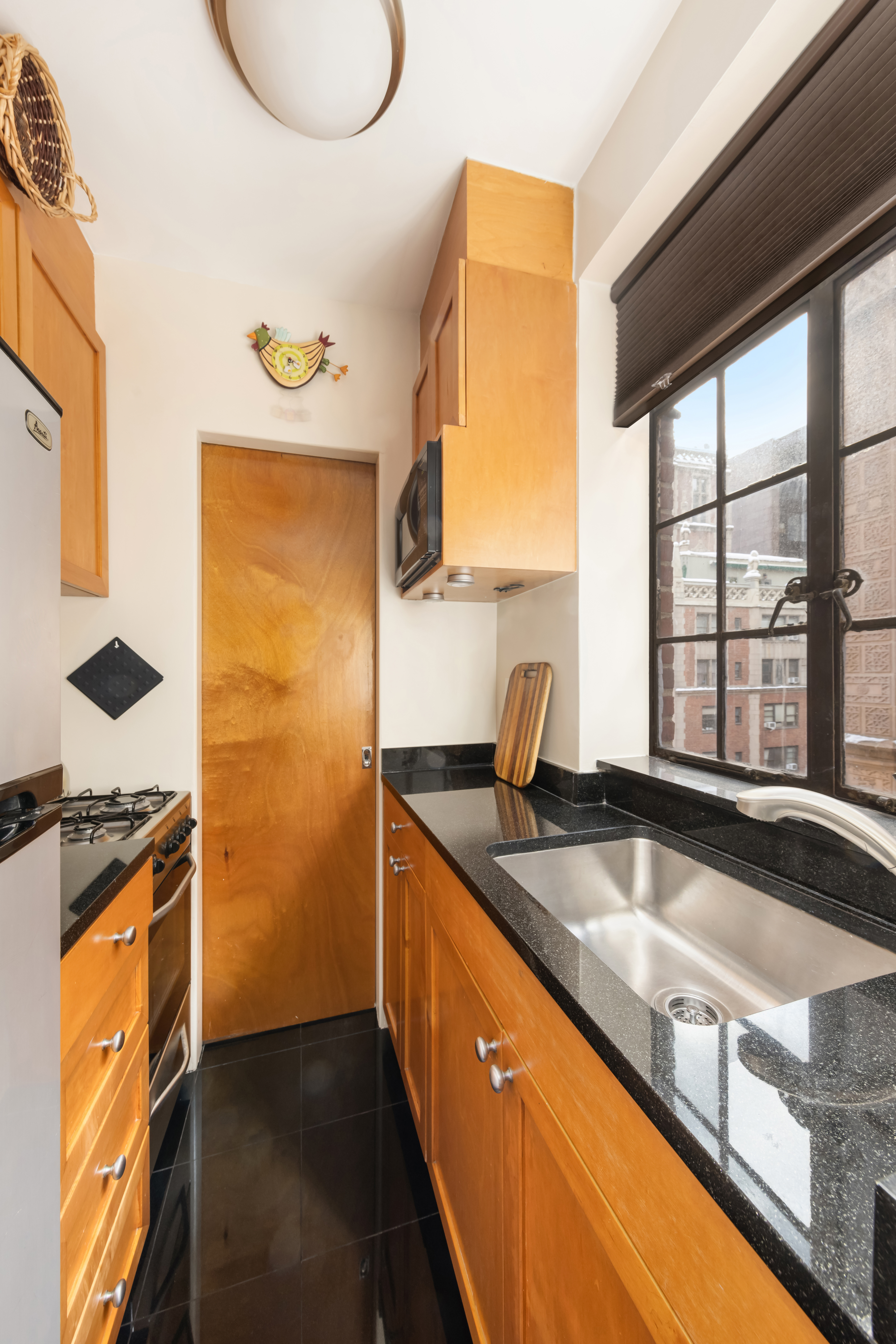 333 East 43rd Street, Unit 906 Manhattan, NY 10017 - Photo 3 of 17 a kitchen with granite countertop a sink and a stove
