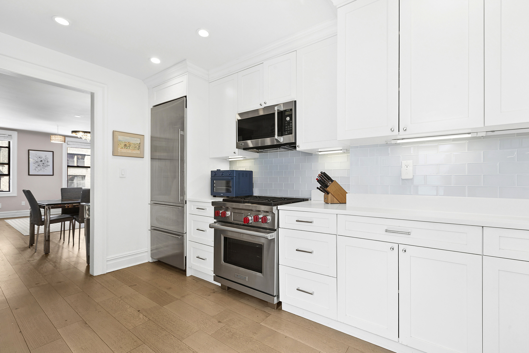 514 West End Avenue, Unit 7B Manhattan, NY 10024 - Photo 2 of 9 a kitchen with white cabinets and stainless steel appliances