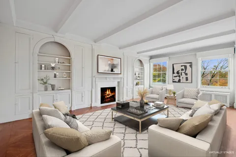 a living room with furniture a fireplace and a large window