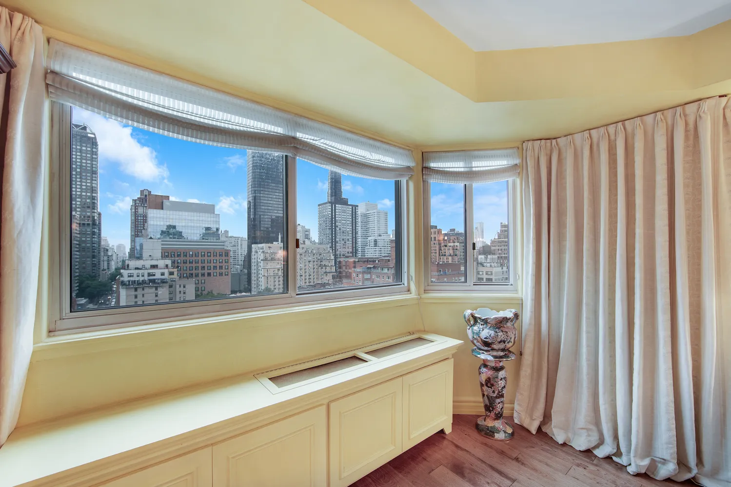 a living room with a large window and a wooden floor