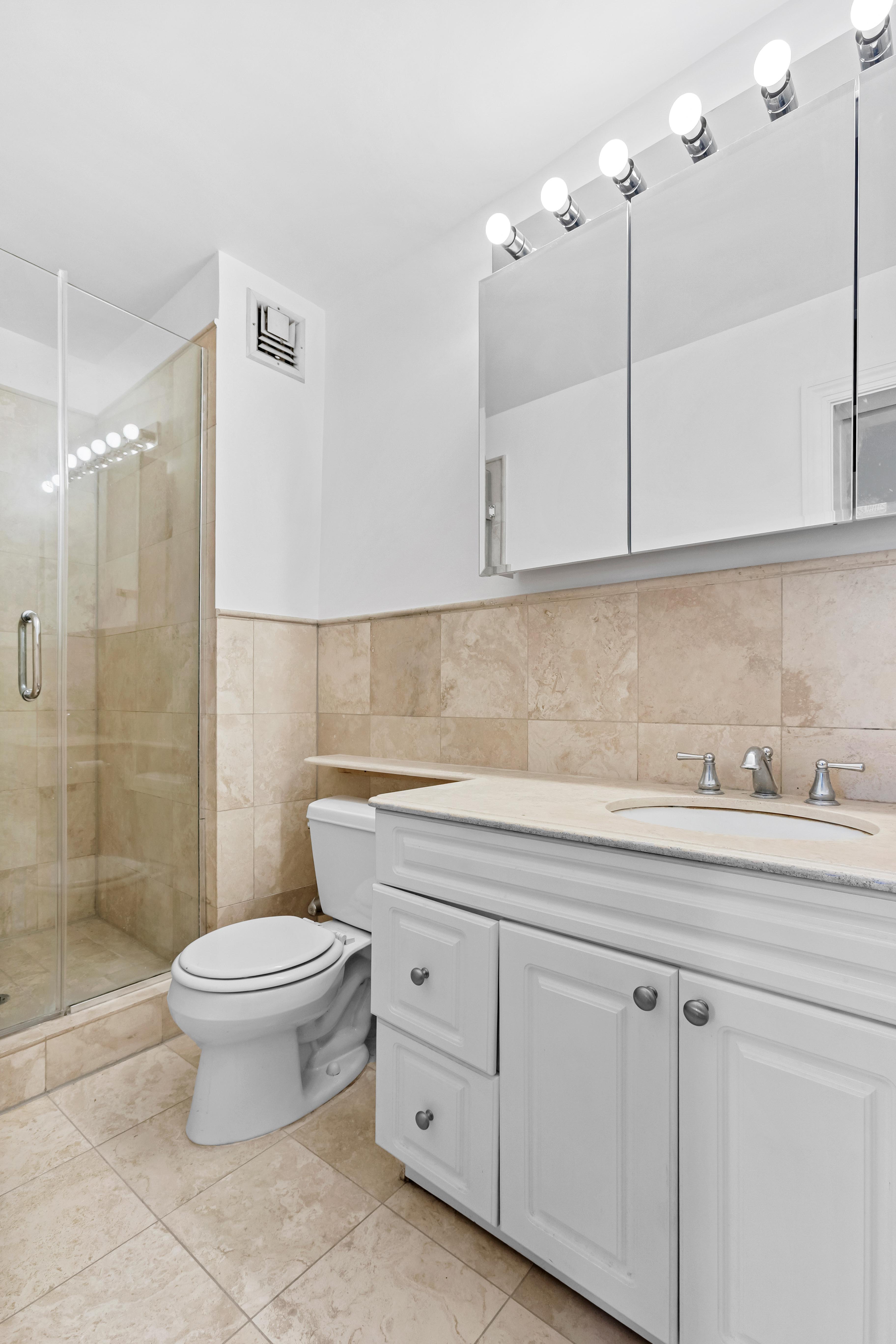 333 East 34th Street, Unit 14D Manhattan, NY 10016 - Photo 5 of 11 a bathroom with a sink a toilet and a mirror