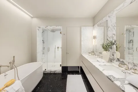 a bathroom with a double vanity sink a toilet a bathtub and shower