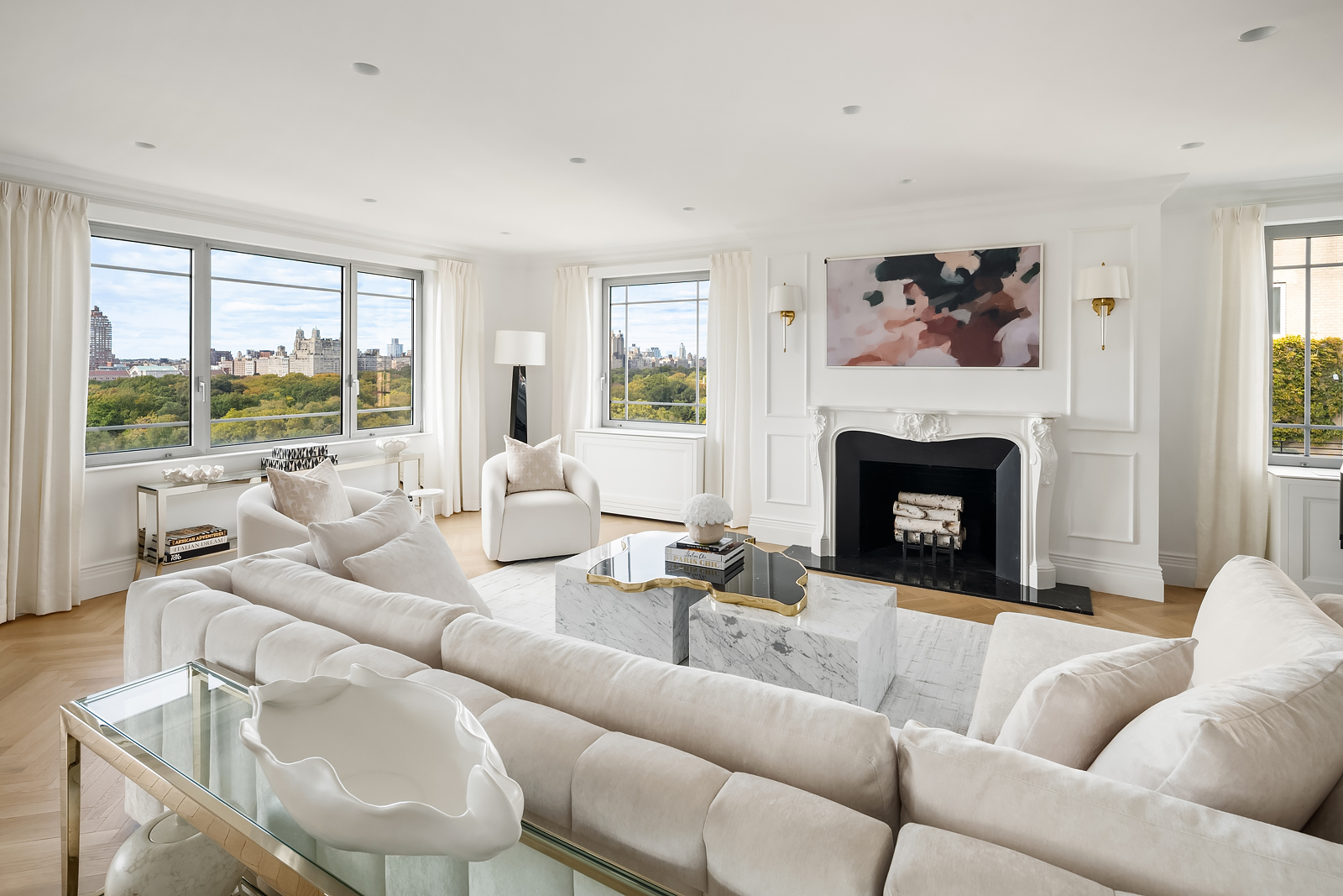 930 5th Avenue, Unit 18A Manhattan, NY 10021 - Photo 2 of 16 a living room with furniture large window and a fireplace
