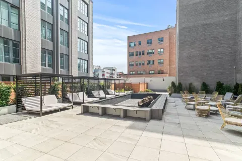 a view of roof deck with outdoor seating and building view