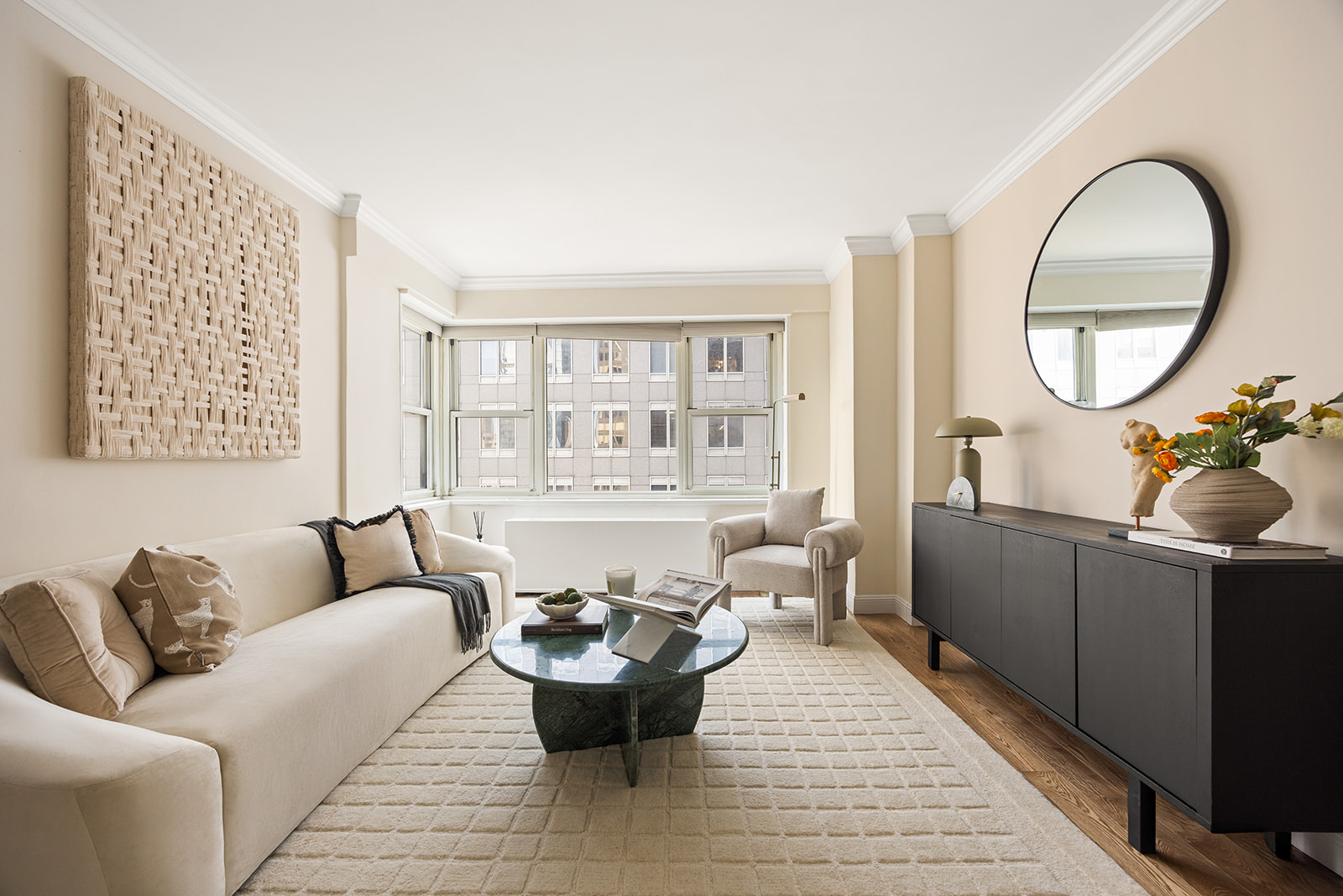 159 West 53rd Street, Unit 27H Manhattan, NY 10019 - Photo 2 of 15 a living room with furniture a wooden floor and a large window