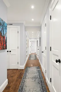 a view of a hallway with wooden floor and staircase