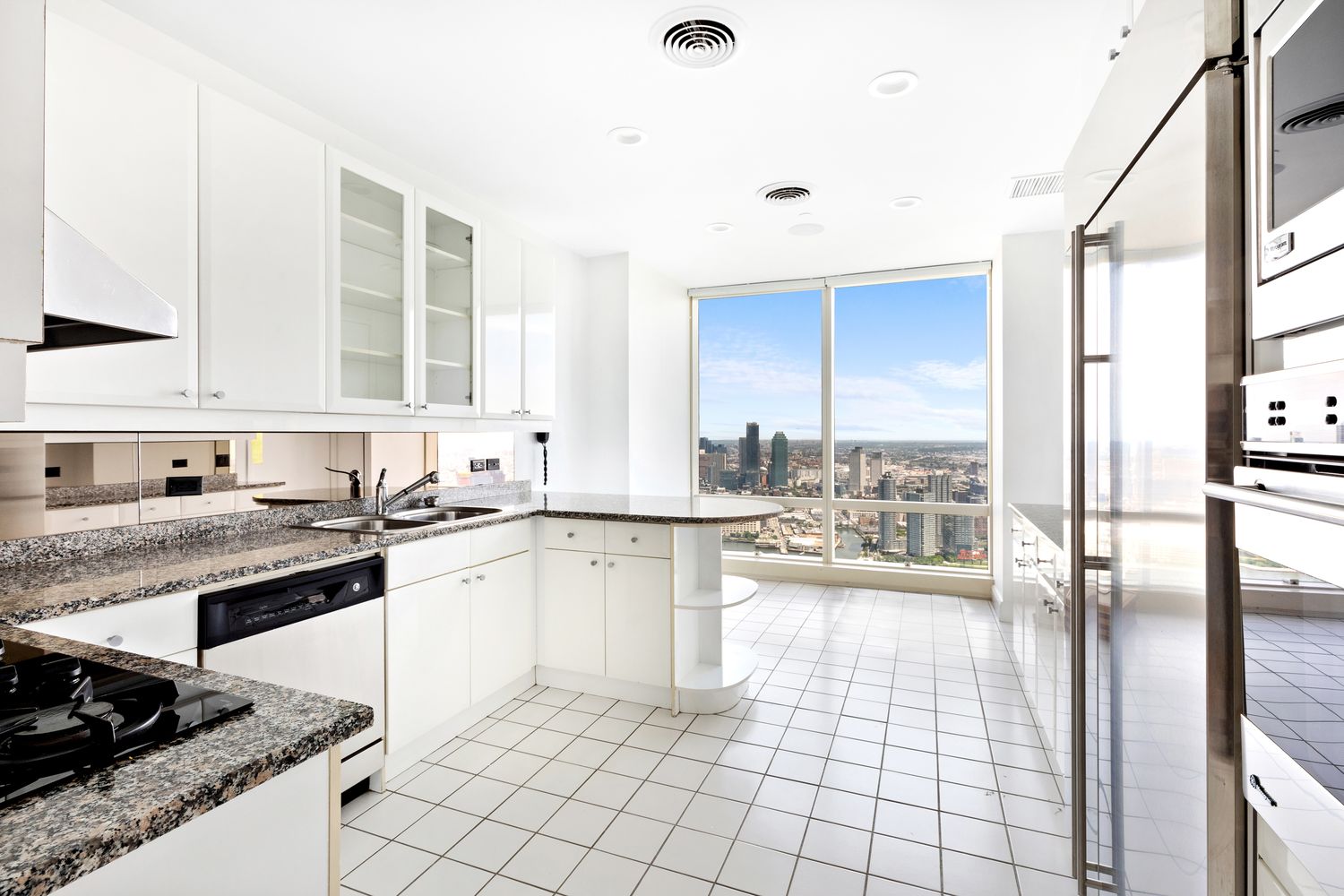845 United Nations Plaza, Unit 63B Manhattan, NY 10017 - Photo 6 of 14 a open kitchen with granite countertop a sink stove top oven and cabinets