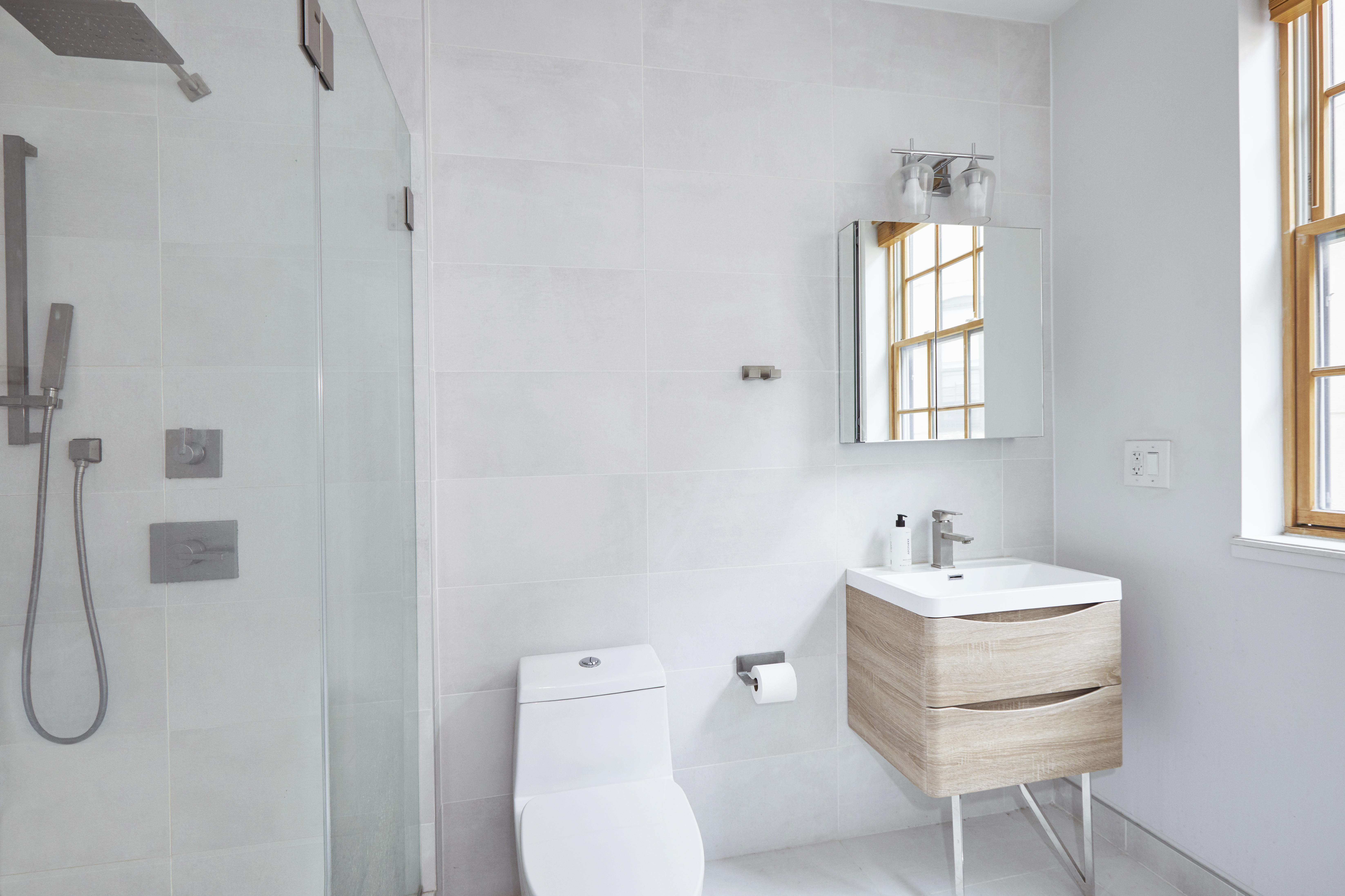 216 Pulaski Street, Unit 3R Brooklyn, NY 11206 - Photo 5 of 7 a bathroom with a sink a toilet and a window