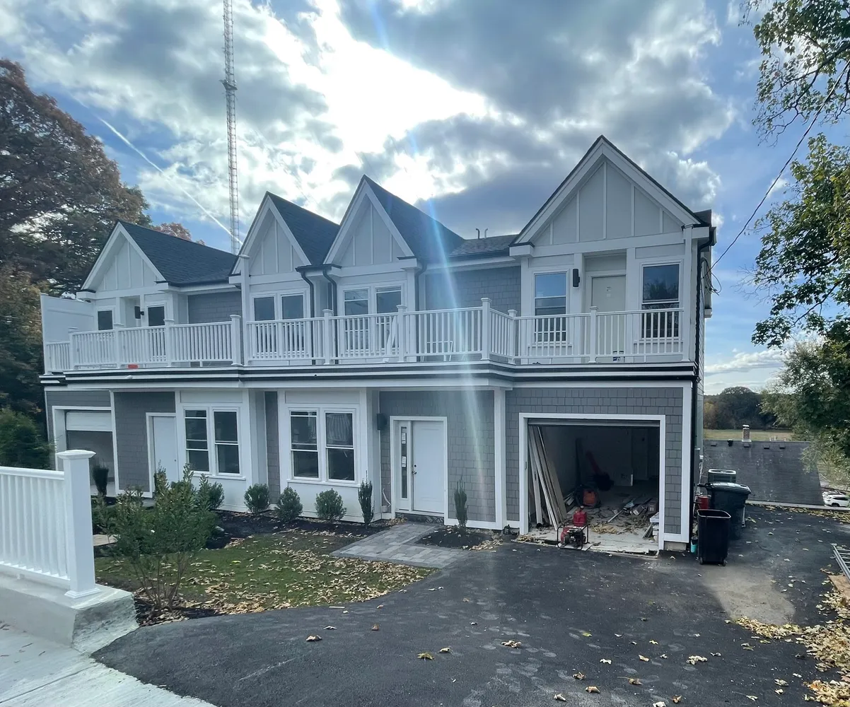 a front view of a house with yard and parking