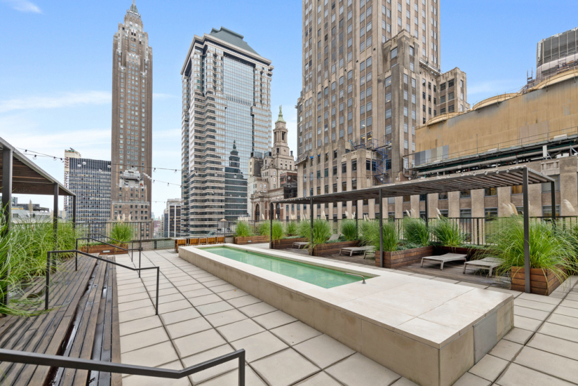 20 Pine Street, Unit 2905 Manhattan, NY 10005 - Photo 7 of 14 a view of a patio with a table and chairs and potted plants