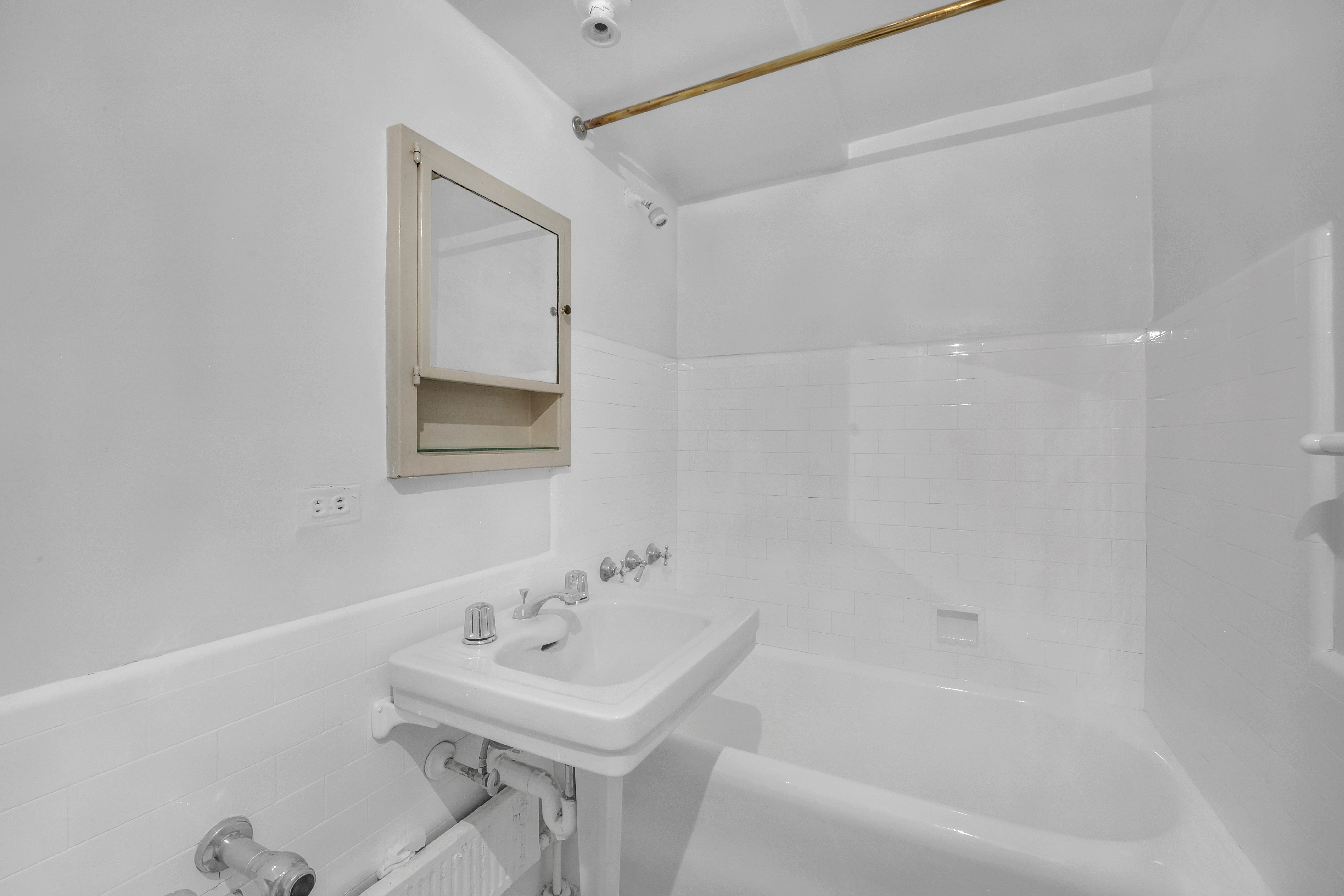 320 East 42nd Street, Unit 516 Manhattan, NY 10017 - Photo 8 of 11 a bathroom with a sink a mirror and a bathtub