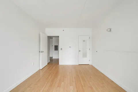 a view of a room with wooden floor and a ceiling fan